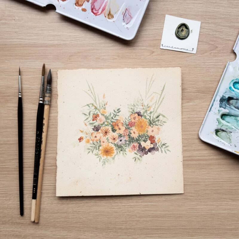 Aquarelle végétale représentant un bouquet de fleurs de champs sur un papier teinté en cours de réalisation par Christelle Lachambre artiste-peintre