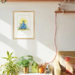 Aquarelle originale La Paix encadrée en décoration intérieure sur le mur d'un salon à la décoration bohème