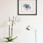 aquarelle moderne L’oeil en décoration intérieure sur le mur blanc d'un salon au dessus d'une console